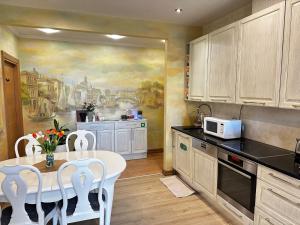 a kitchen with a table and a painting on the wall at PhucAn Shared-Apartment in Riga in Riga