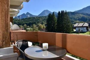 a table and chairs on a balcony with mountains at Gemütliche Wohnung mit Bergblick und Nähe Faaker See in Latschach