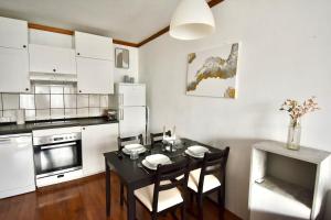 a kitchen with a black table and chairs in a room at Gemütliche Wohnung mit Bergblick und Nähe Faaker See in Latschach +6 photos
