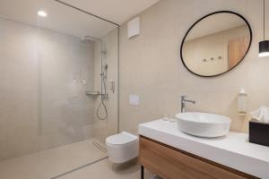 Un baño con lavabo, inodoro y espejo. en Hotel Labineca, en Gradac 32 fotos más