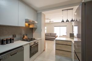 a kitchen with white cabinets and a stove top oven at Apartment 35 - 1 On York in George