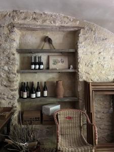 a room with shelves with wine bottles and a chair at Le Clos de Gordes in Gordes