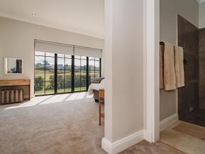 1 dormitorio con una gran puerta de cristal con vistas en Moorlands Manor, en George