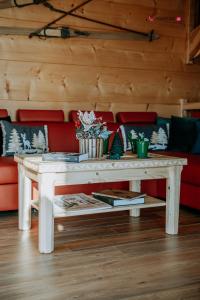 een witte salontafel voor een rode bank bij Topory Prestige House sauna & jacuzzi in Zakopane