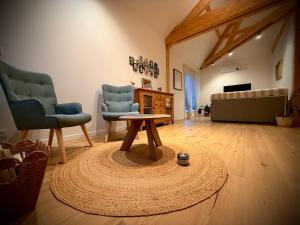 a living room with two chairs and a coffee table at Gîte La petite Reine de l Ouche in Sainte-Marie-sur-Ouche