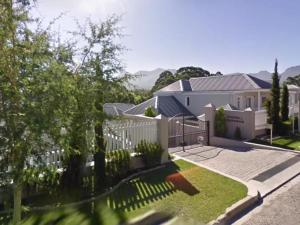 a house with a white picket fence at Fifty1 on Long on Kingswood Golf Estate in George
