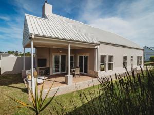 a white house with a roof at Fifty1 on Long on Kingswood Golf Estate in George