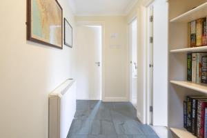 a hallway with bookshelves and a staircase with books at The Screes Apartment - Short stroll from Wastwater in Nether Wasdale