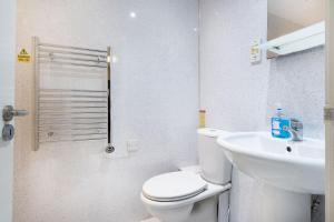 a white bathroom with a toilet and a sink at The Screes Apartment - Short stroll from Wastwater in Nether Wasdale +7 photos