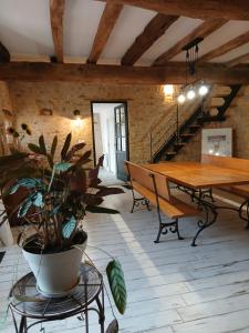 a dining room with a wooden table and a bench at Le Tamaris Chambres d'hôtes in Sainte-Hermine
