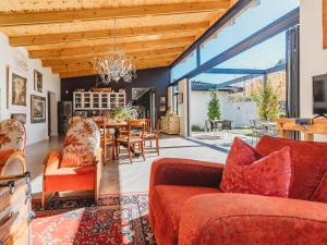 a living room with red furniture and a dining room at Knights Retreat on Kingswood Golf Estate in George