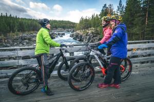 un grupo de personas de pie en un puente con bicicletas en Lemonsjø Fjellstue og Hyttegrend, en Randsverk