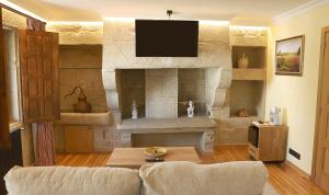 パドロンにあるVilla Garabánの石壁のリビングルーム(テレビ付)