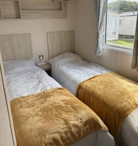 Voodi või voodid majutusasutuse Cosy Caravan With Free Wi-Fi At Dovercourt Holiday Park Ref 44502R toas