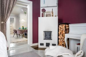 a room with a fireplace and a dining room with a table at Hirsihuvi 1826 in Oulu +13 photos