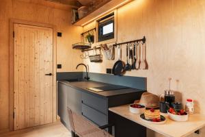 a kitchen with a sink and a counter with a table at Cabins at Bogee Farm in Saint Ervan +28 photos