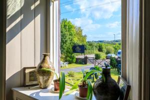 une fenêtre avec trois vases assis sur une table dans l'établissement Picton House Exclusive Christmas, à Llandowror 14 autres photos