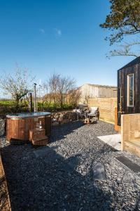 a backyard with a hot tub and a building at Cabins at Bogee Farm in Saint Ervan