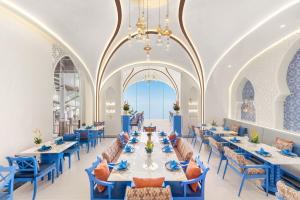 une salle à manger avec tables et chaises et un lustre dans l'établissement Royal Cliff Beach Hotel Pattaya, à Pattaya (sud)