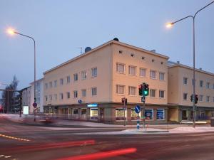ein Gebäude auf einer Straße mit grüner Ampel in der Unterkunft Snowlight Apartment By BookLapland in Rovaniemi