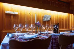 a table with wine glasses and flowers on it at La Hohmatt in Tüscherz-Alfermée