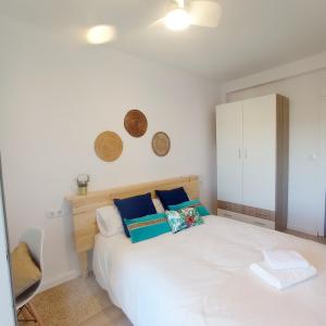1 dormitorio con 1 cama blanca y armario blanco en Habitación Adra Puerto, en Adra