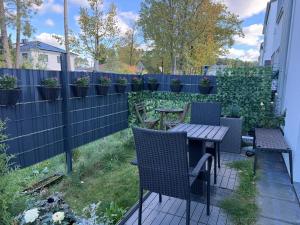 a patio with a table and chairs and a fence at Cosy room near Berlin and close to Tesla Factory in Brandenburg in Vogelsdorf