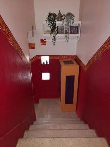 a stairway with red walls and a yellow door at Chambre chez l habitant in Crolles