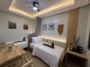 a hotel room with two beds and a table at Inngo Tourist Inn in El Nido