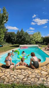 a group of people playing in a swimming pool at Le Clos Julo - Studio cosy à la campagne avec piscine in Villiers-sur-Loir
