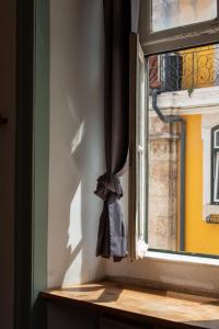 a window with a bag hanging from the curtain at Rossio Hostel in Lisbon