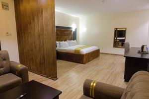 a hotel room with a bed and a couch at Vizit Hotel & Suites in Benin City
