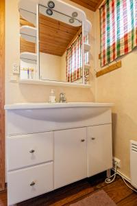 a bathroom with a white sink and a mirror at Sjøstrand Rorbuer in Ballstad