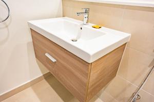 ein Badezimmer mit einem weißen Waschbecken und einer Dusche in der Unterkunft F1 Lovers Escape Yas Golf Studio Near Yas Marina Circuit in Abu Dhabi + 29 Fotos