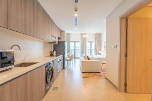 eine Küche mit Spüle, Waschmaschine und Trockner in der Unterkunft F1 Lovers Escape Yas Golf Studio Near Yas Marina Circuit in Abu Dhabi