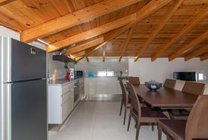 eine Küche und ein Esszimmer mit einem Tisch und einem Kühlschrank in der Unterkunft Demargia Villa A - Loft Apartment in Áno Yerakaríon
