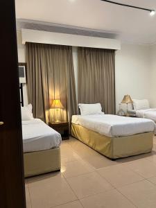 Una habitación de hotel con dos camas y dos lámparas. en marya appartment, en Medina