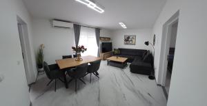 a living room with a table and a couch at Apartman Bugi Vukovar in Vukovar