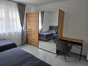 a bedroom with a mirror and a desk and a chair at Apartman Bugi Vukovar in Vukovar