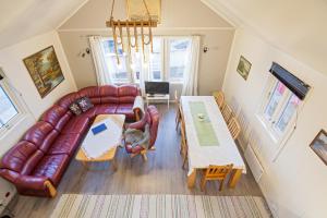 a living room with a leather couch and a table at Sjøstrand Rorbuer in Ballstad