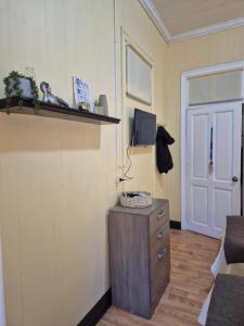 a room with a wooden dresser and a door at alojamiento en punta arenas in Punta Arenas