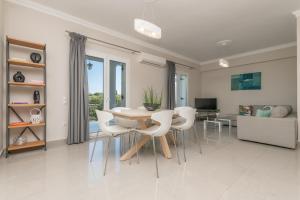 a dining room with a table and chairs and a couch at Demargia Villa A - First Floor Apartment in Áno Yerakaríon
