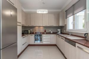 a kitchen with white cabinets and a large window at Demargia Villa A - First Floor Apartment in Áno Yerakaríon