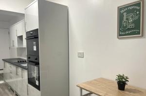 eine Küche mit einem Tisch und einem schwarzen Backofen in der Unterkunft New Medway Private Double room with private bathroom close to hospital and station in Gillingham + 2 Fotos