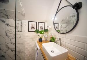a bathroom with a sink and a mirror at Maya's Flats - Dluga 66 Attic Gdansk in Gdańsk +11 photos