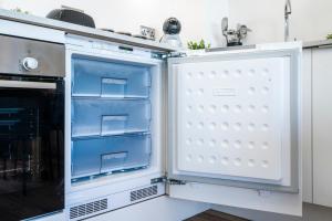 an open refrigerator in a kitchen next to a stove at Central Gravesend 1BR, Kitchen, Wi-Fi, Sleeps 2, Parking in Gravesend