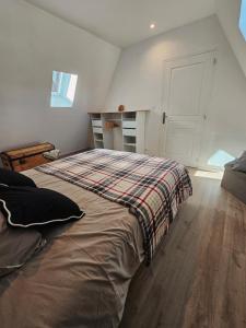 a bedroom with a bed with a plaid blanket on it at Gîte a la source in Bergholtz-Zell