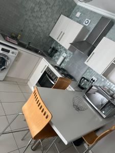 a kitchen with a white table and chairs in it at Villa Kristine 3 in Windhoek +2 photos