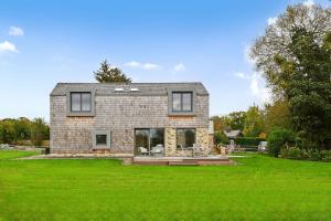 a brick house with a green lawn in front of it at Brook Lodge Farm in Uckfield