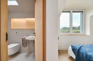 a bathroom with a sink and a toilet and a window at Brook Lodge Farm in Isfield +28 photos